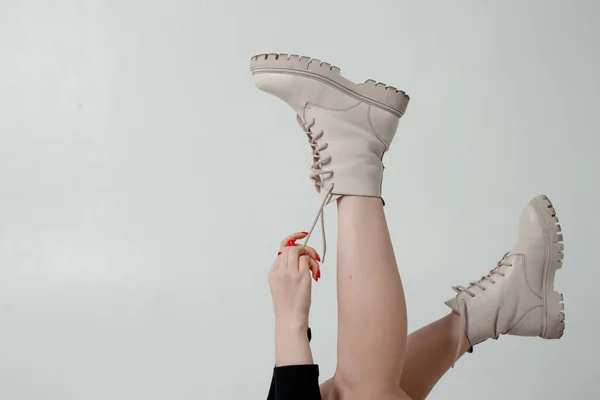 白い背景にブーツを着たセクシーな女性の足 ファッショナブルな2023年に白い背景の女の子の足に新しいコレクションから黒革の靴の女性 靴を逆さにした女の子の足 — ストック写真