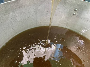 Bal çömleğe dökülür. Büyük bir sarnıçta bal. Yüksek kalite fotoğraf