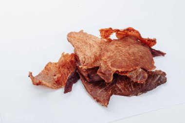 Kuru yaşlı bir adamın barbekü restoranında servis edilmek üzere kurutulmuş bifteği dikkatlice dilimlerken yakın plan çekimi. Beyaz bir arka planda. Yüksek kalite fotoğraf