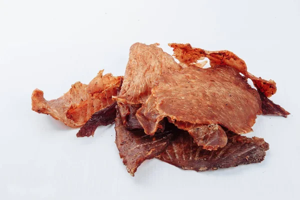 Kuru yaşlı bir adamın barbekü restoranında servis edilmek üzere kurutulmuş bifteği dikkatlice dilimlerken yakın plan çekimi. Beyaz bir arka planda. Yüksek kalite fotoğraf