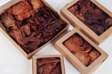 İçinde kurutulmuş köpek maması olan karton kutular, en büyüğü açılmış, sığır eti ve tavuktan gelen kuru et tadı ile dolu. Ev yapımı hayvan maması, sağlıklı ve doğal. Uzayı kopyala Yüksek