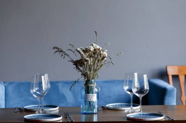 tableware Glasses, flower fork, knife served for dinner in restaurant with cozy interior. High quality photo