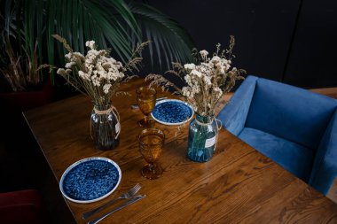 Simple table setting with flowers on dark background. High quality photo