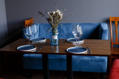 Beautiful table setting with glasses of wine and rose in dark room. Romantic dinner for Valentines day. High quality photo