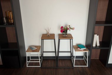 Sandalye ve vazonun yanındaki eski püskü ahşap masa modern dairede dekorasyonlu aydınlık duvarlara karşı. Yüksek kalite fotoğraf