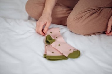 Kadın ayaklarına yeşil çorap giyiyor. Beyaz arka planda izole edilmiş. Yüksek kalite fotoğraf