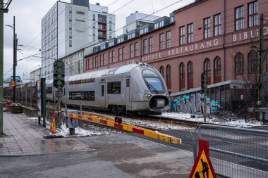 Stockholm, Sweden - March 10, 2023: SJ X40 swedish double decker train on the way through the city clipart