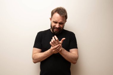 Bilek ağrısı sorunu: sakallı hippi orta yaşlı adam bileğini tutuyor.