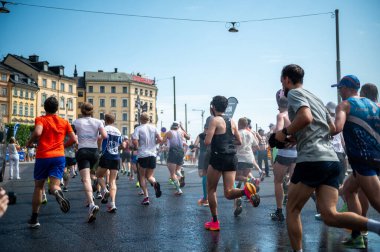 Stockholm, İsveç - 1 Haziran 2024: Adidas 'ın yıllık Stockholm Maratonu, şehir merkezinde güneşli ve sıcak havayla koşan sporcular
