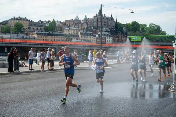 Stockholm, İsveç - 1 Haziran 2024: Adidas 'ın yıllık Stockholm Maratonu, çeşme serpme noktası, sporcular sudan ferahlıyor
