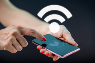 Akıllı ev. Akıllı telefonunu kullanarak akıllı evi kontrol eden bir kadın..