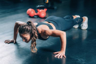 Spor salonunda şınav çeken bir kadın. Kuvvet Eğitimi.