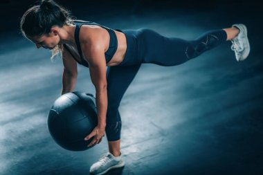 Duvar Topu ile egzersiz yapan bayan sporcu.