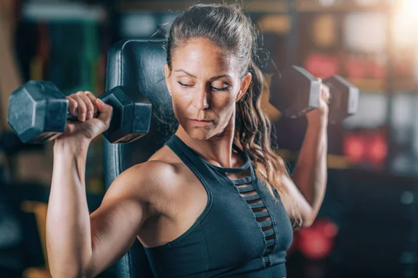 Spor Salonunda Dambıllarla Egzersiz Yapan Bayan Sporcu Kuvvet Eğitimi — Stok fotoğraf