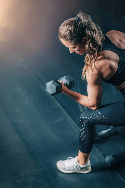 Spor Salonunda Dambıllarla Egzersiz Yapan Bayan Sporcu — Stok fotoğraf