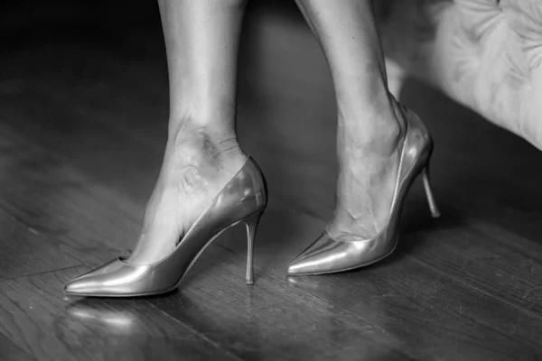 Silver high heels, woman wearing silver shoes.