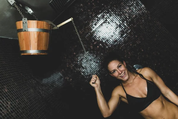 Wooden Bucket with Cold Water in Spa Center.