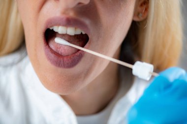 Woman Inserting a swab into the mouth, collecting a saliva sample for DNA analysis 