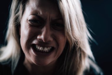 Anger - intense portrait of an angry woman on black background 