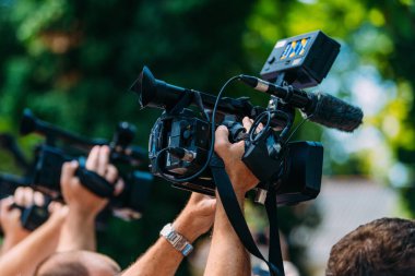 Cameras at a media conference outdoors.