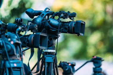 Cameras at a media conference outdoors.
