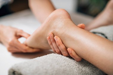Ayurvedic Foot Massage. Hands of Ayurveda Practitioner massaging female foot 
