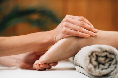 Ayurvedic Foot Massage. Hands of Ayurveda Practitioner massaging female foot 