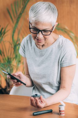 Akıllı telefon uygulaması kullanarak kan şekeri seviyesini ölçüyorum.