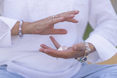Kadın kristal iyileştirici terapist meditasyon yapıyor, beyaz selenit kristalle bolluk gösteriyor. Enerji işi