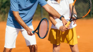 Clay Court 'ta Kıdemli Kadın' la tenis hocası. Tenis dersi alan bir kadın..