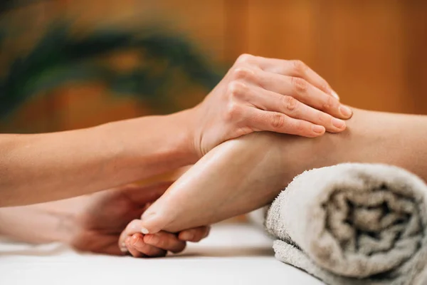 Ayurvedic Foot Massage. Hands of Ayurveda Practitioner massaging female foot