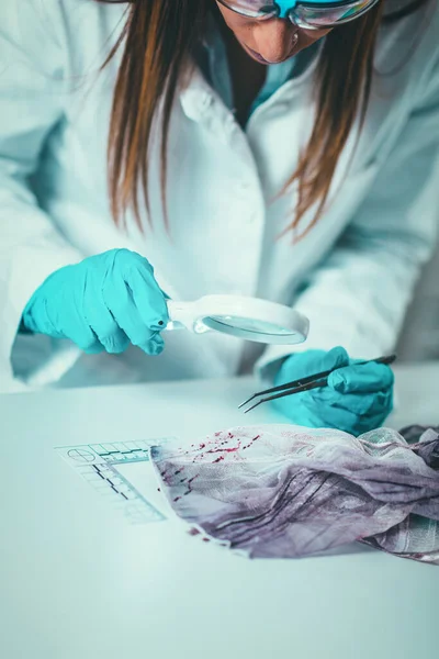 血の証拠を使用して繊維を調べる研究所法医学科学者で科学捜査 — ストック写真