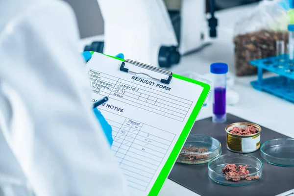 식품의 실험실 기술자가 동물의 검사에 노트를 작성하다 — 스톡 사진
