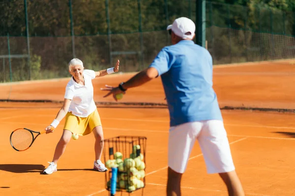 Mujer Mayor Practicando Tenis Con Instructor —  Fotos de Stock