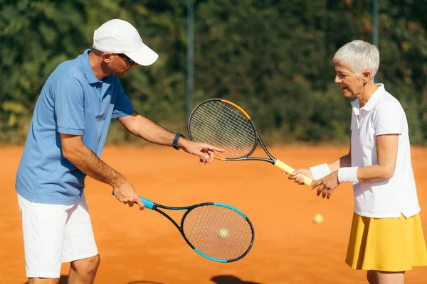 Aktivní Senior Woman Cvičení Tenis Instruktorem — Stock fotografie
