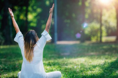 Meditation. Young woman practicing yoga and meditating by the water.
