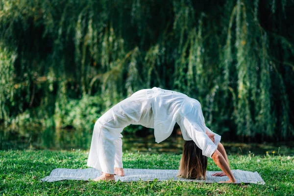 Yoga Kvinna Öva Utomhus Gör Bro Pose Grön Naturlig Bakgrund — Stockfoto