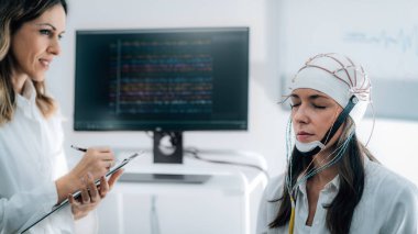 Nöroloji Laboratuvarındaki Doktor ve Hasta EEG taraması yapıyor.  