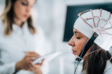 Nöroloji Laboratuvarındaki Doktor ve Hasta EEG taraması yapıyor.  