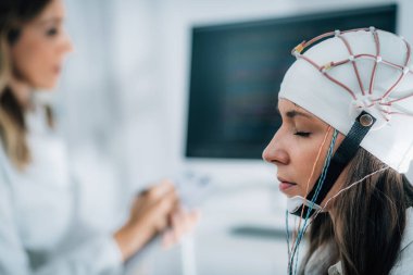 Nöroloji laboratuarındaki kadın hasta EEG taraması yapıyor.