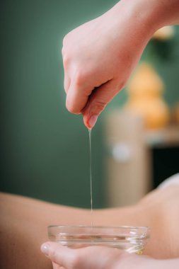 Masaj yağı. Kadınların sırtına aromatik masaj yağı döken terapist. 