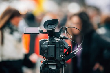 Halk protestolarında televizyon kamerası, sokak gösterileri, arka planda bulanık insanlar