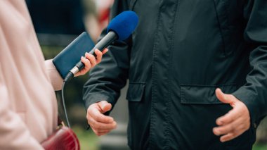 Haber muhabirleri bir protestoda bir sözcüyle röportaj yapıyor.
