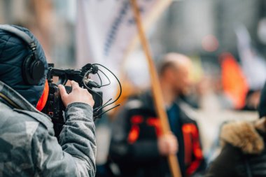 Halk protestoları sırasında şehir sokaklarından haber ekibi, arka planda kalabalık