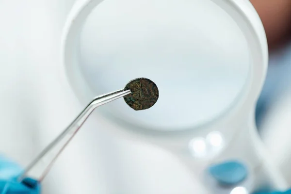 虫眼鏡で古代のコインを調べる専門家 — ストック写真