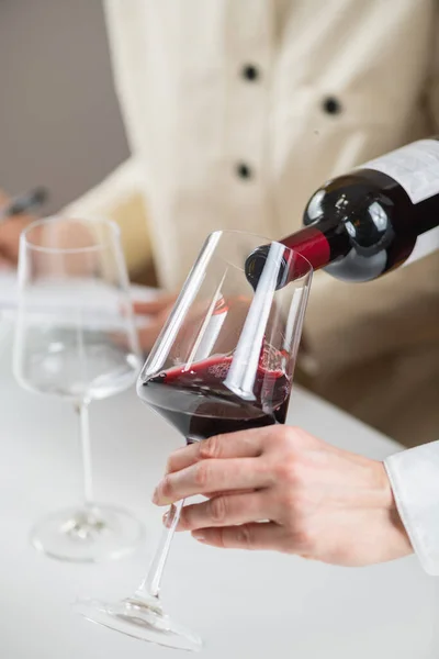 品酒经验 酒保将红酒从酒瓶倒入酒杯中 展示了为客人提供葡萄酒的适当技巧 — 图库照片
