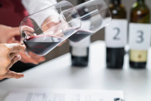 赤ワインの試飲 参加者は ワインのテイスティングイベントで異なる赤ワインの色を比較し ワインの年齢 ブドウの品種 および色相に基づいて他の重要な詳細を識別することを学ぶ — ストック写真