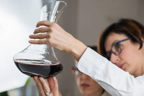 品酒活动 质量评估 一个梦游者用酒瓶来审视葡萄酒 并根据葡萄酒的外观 味道和口感来评价葡萄酒的品质 — 图库照片