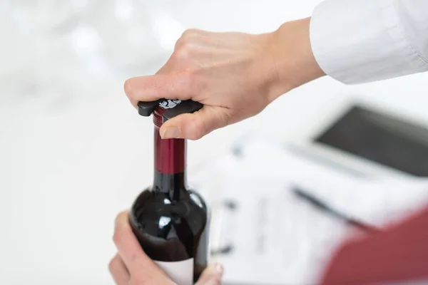 ワインの試飲体験 ソムリエはワインボトルの上面を覆う箔を除去し サービス用のワインボトルを準備する適切な方法を説明します — ストック写真