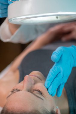 Dermatolojik değişiklikler için hastanın cildini incelemek, koşulları belirlemek ve tedavi seçeneklerini keşfetmek için tasarlanmış teşhis süreci.  